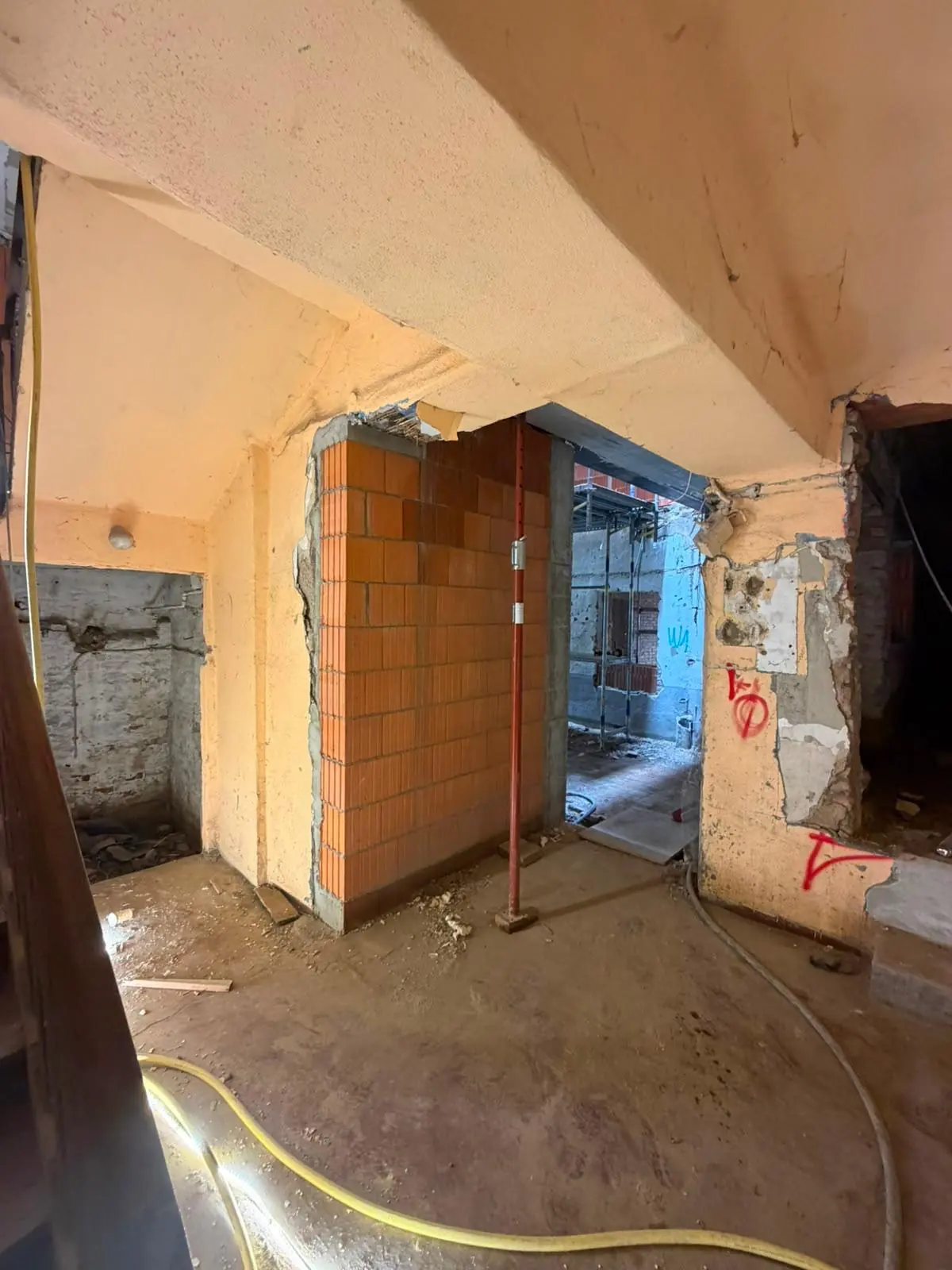 Innenraum im Rohbau mit neu gemauerten Ziegelwänden und freigelegtem Bestand