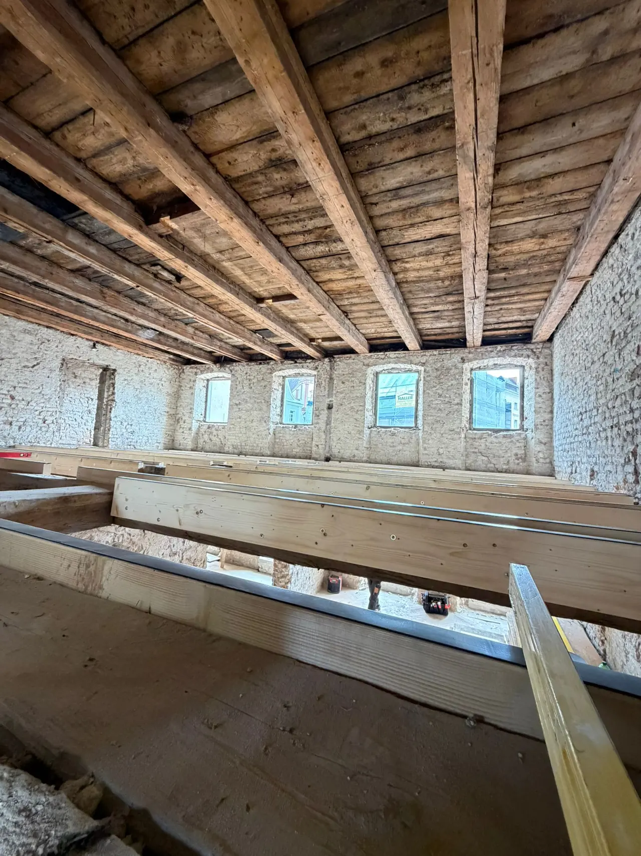 Geschoss mit freigelegter Holzbalkendecke und historischem Mauerwerk